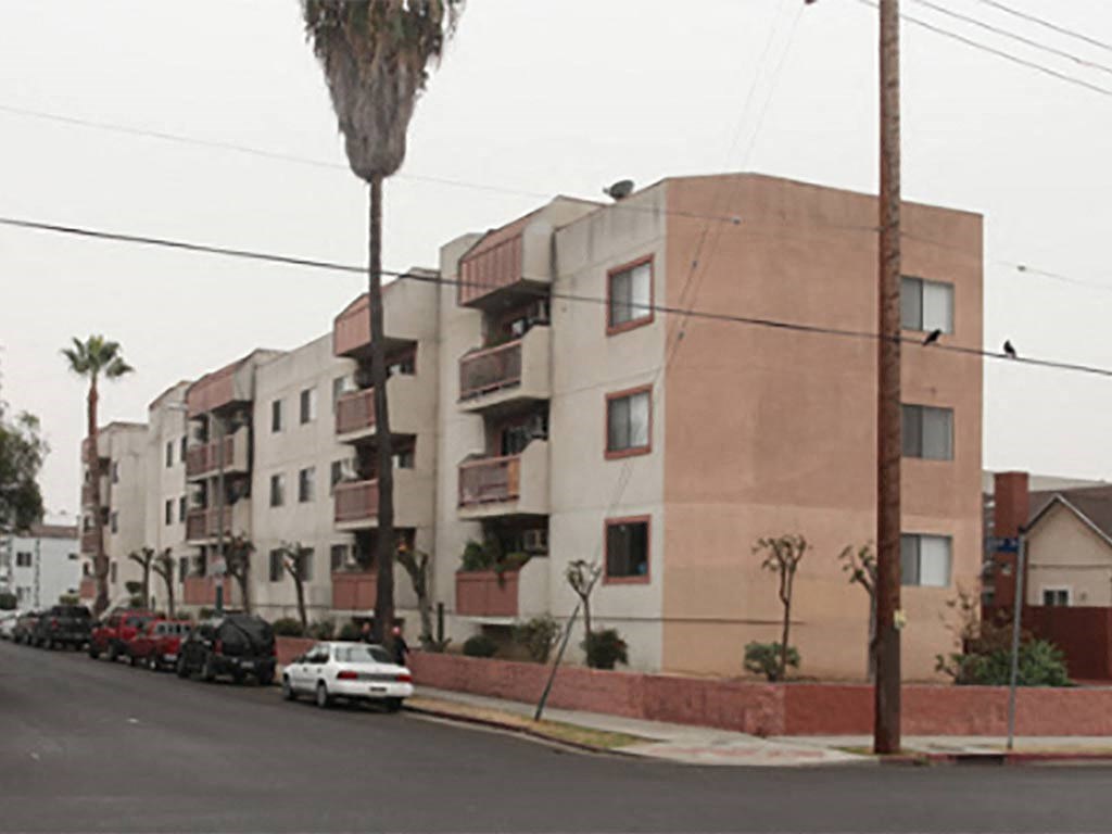 an apartment building with cars parked in front of it