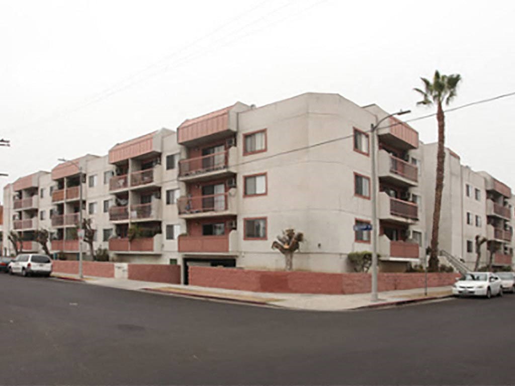 an apartment building on a street corner with cars