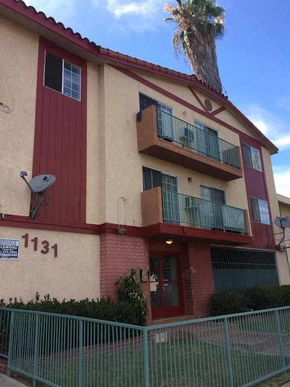 a building with a balcony and a palm tree