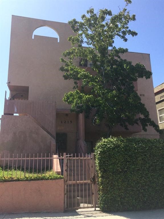 a building with a gate and a tree in front of it