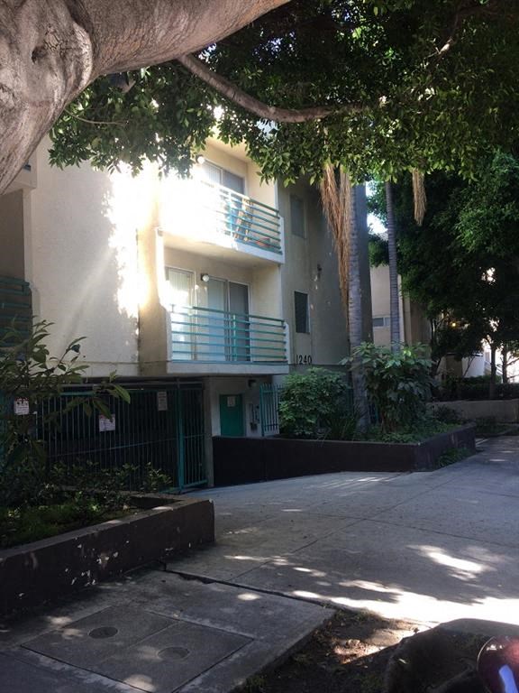 an apartment building with a sidewalk and trees