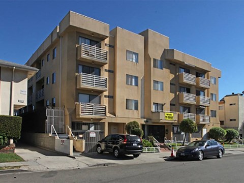 an apartment building with cars parked in front of it