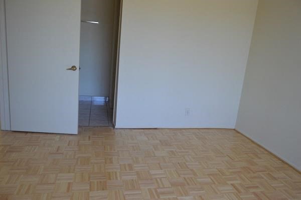 an empty room with a white door and a wooden floor
