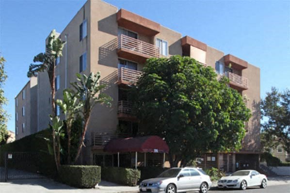 an apartment building with cars parked in front of it