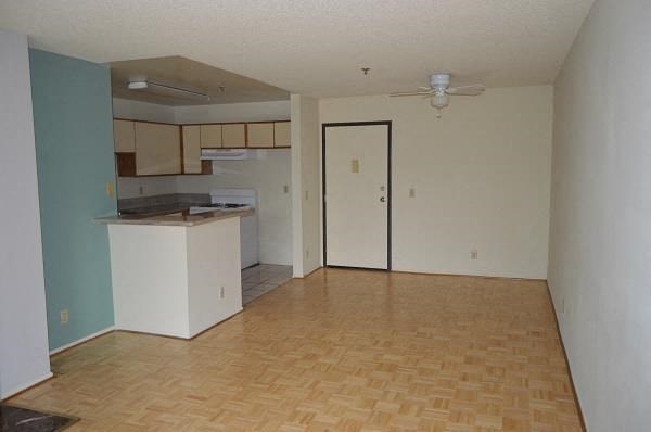 an empty living room with a kitchen in it