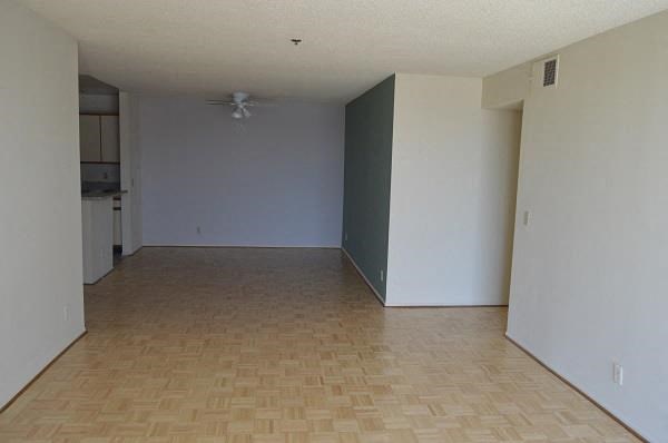 an empty living room with white walls and a wooden floor