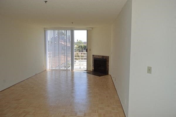 an empty living room with a wood floor and a fireplace