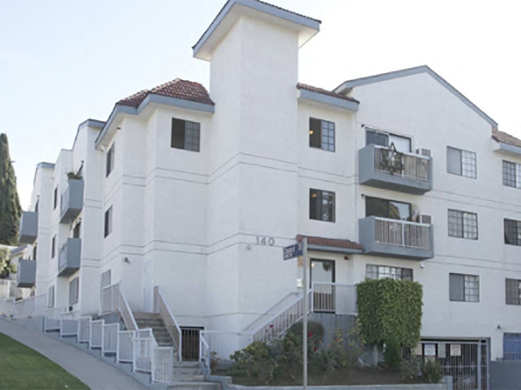 a row of white apartment buildings on a street