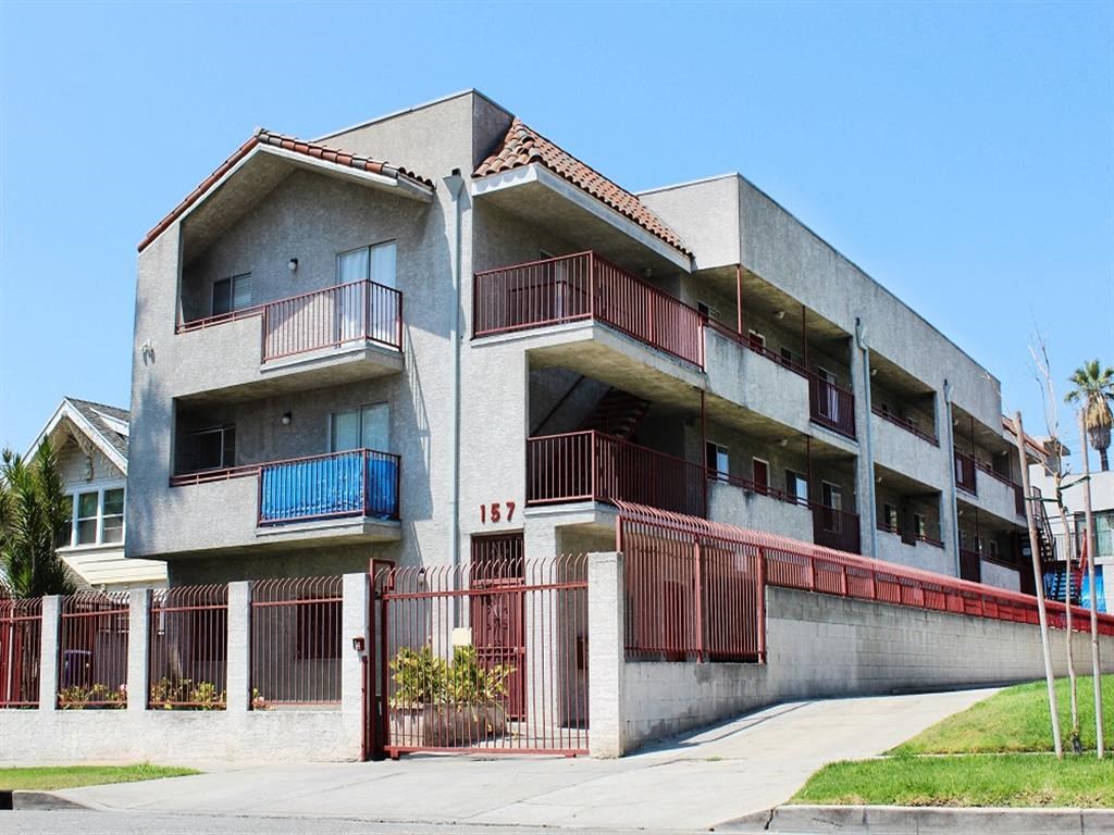 an apartment building with balconies and a sidewalk