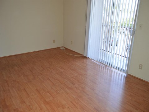 a living room with a wood floor and a window