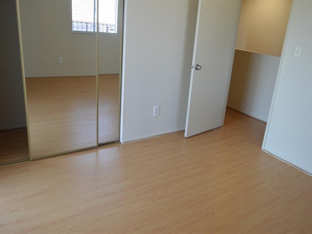 an empty room with a wooden floor and a door