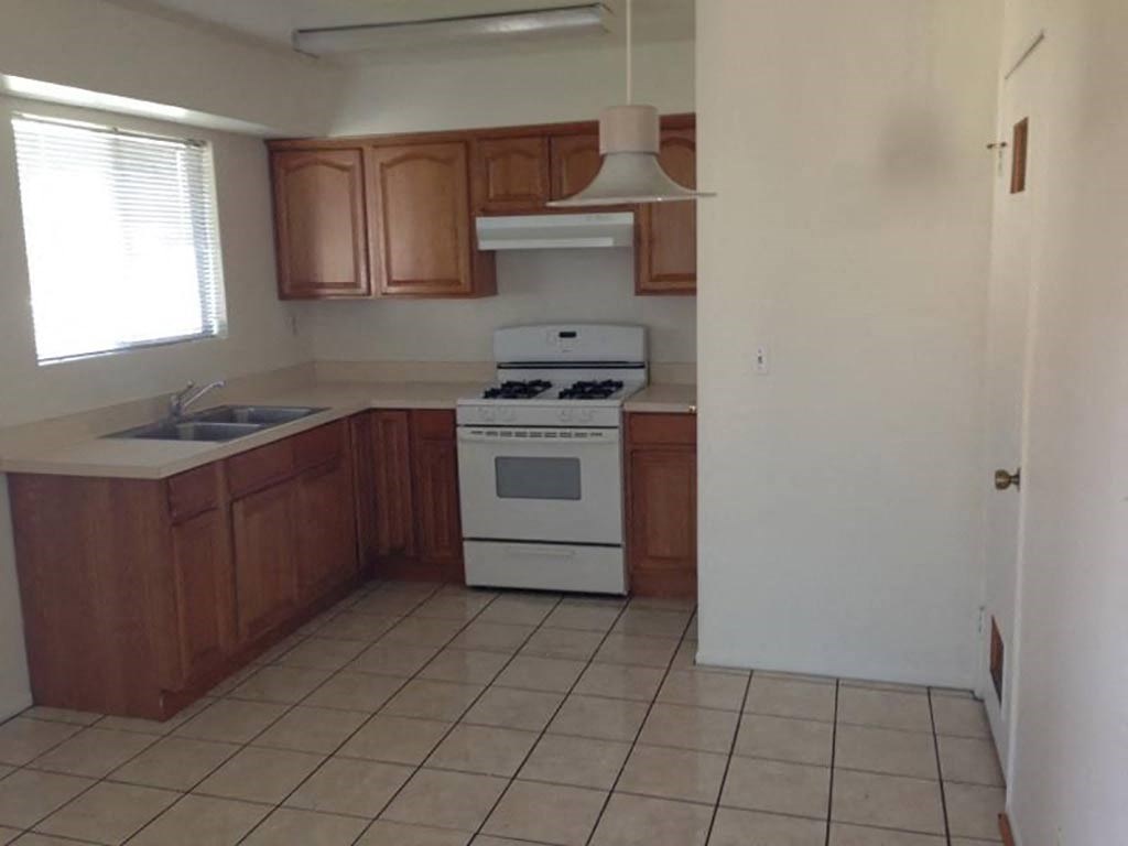 an empty kitchen with a stove and a sink