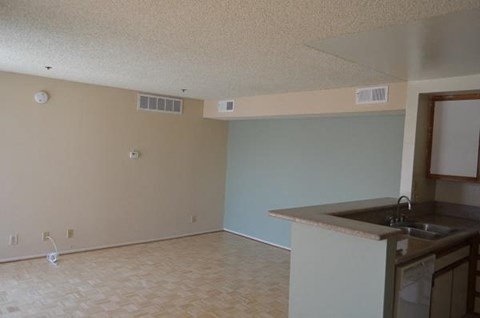an empty room with a kitchen and a sink