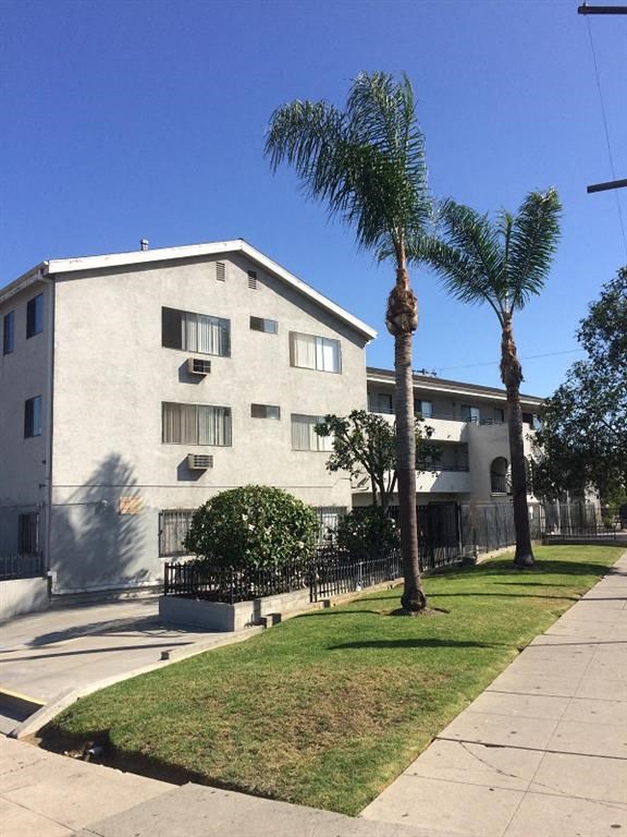 an apartment building with palm trees in front of it
