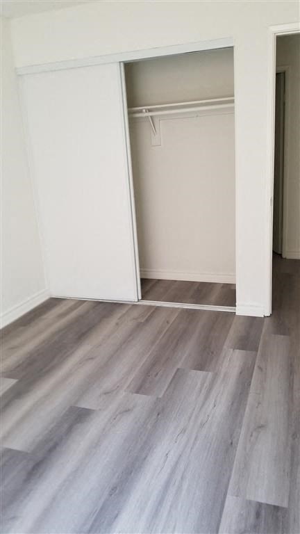 an empty room with wood floors and a closet