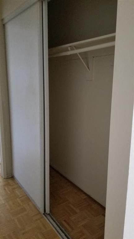 a closet with a mirrored door and a wood floor