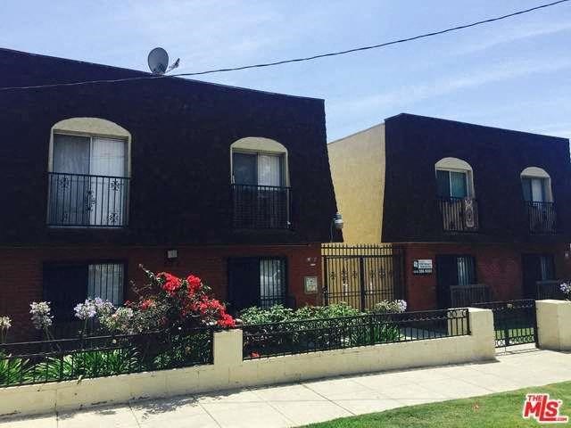 a building with a fence and flowers in front of it