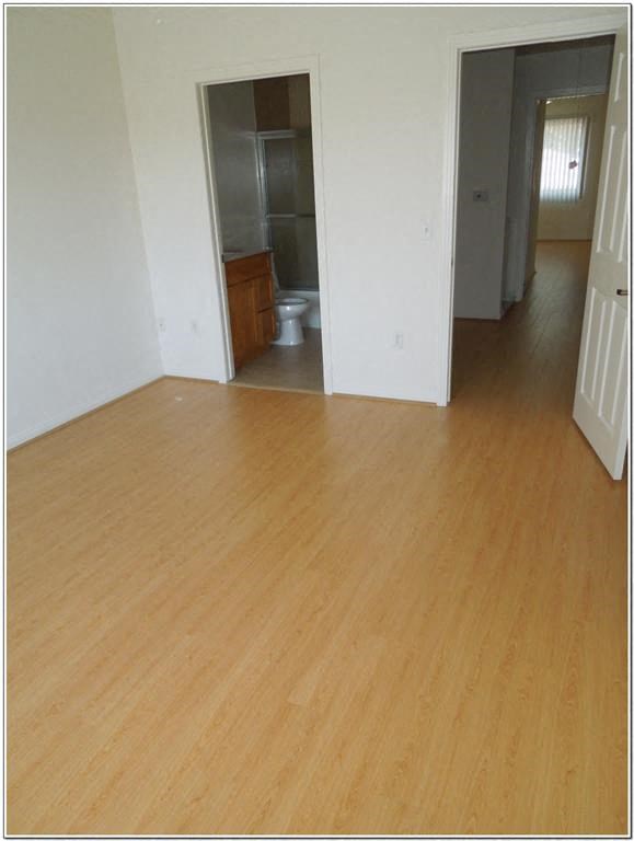 an empty living room with a wooden floor