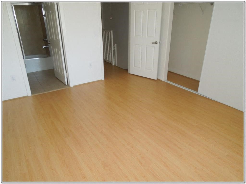 an empty living room with a wooden floor