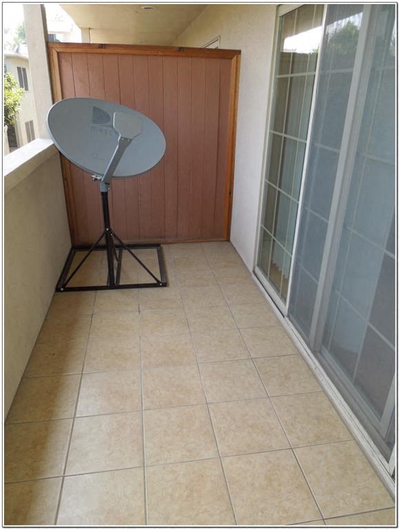 a balcony with a fan and a table on it