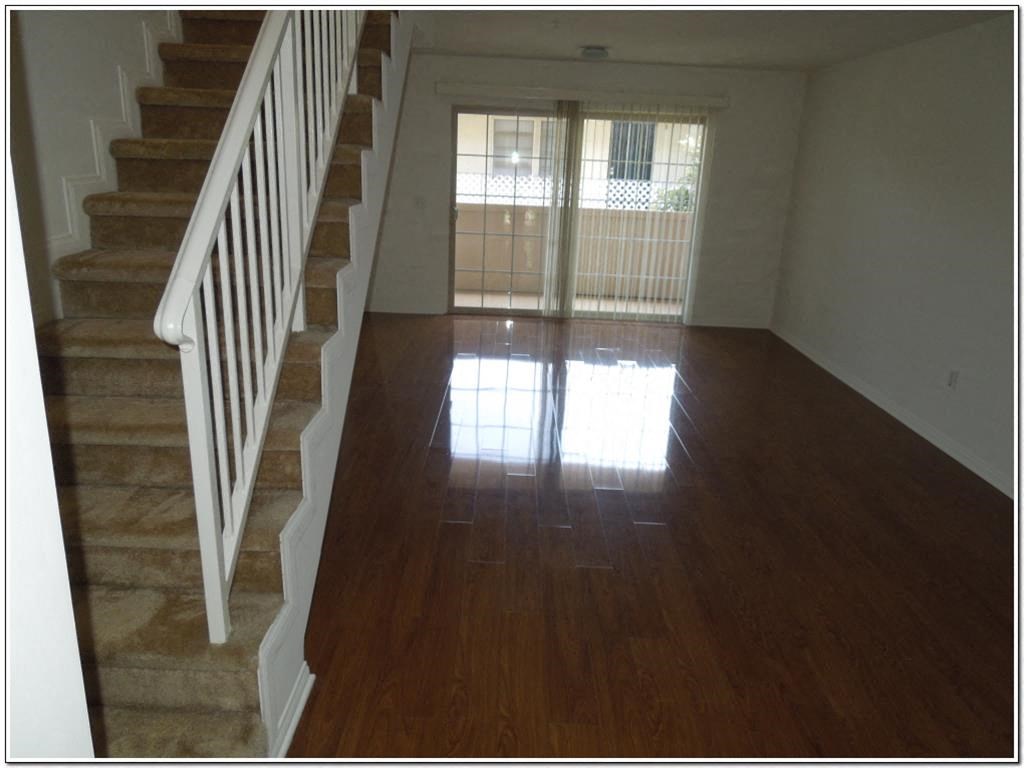 an empty living room with a hard wood floor and stairs