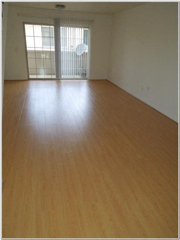 an empty living room with a wooden floor