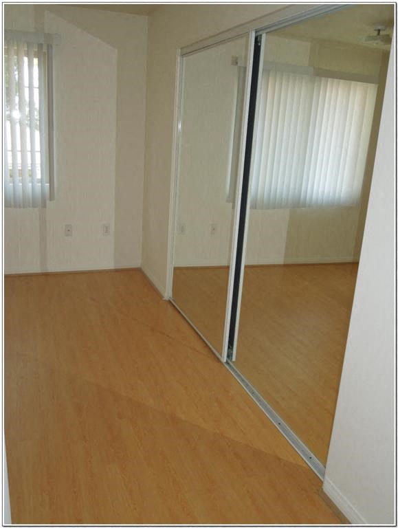 a room with a mirror and a wooden floor