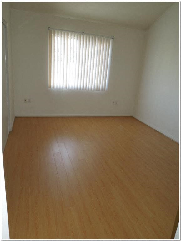 an empty room with wooden floors and a window