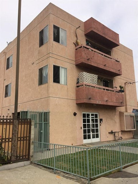 a building with two balconies and a fence in front of it