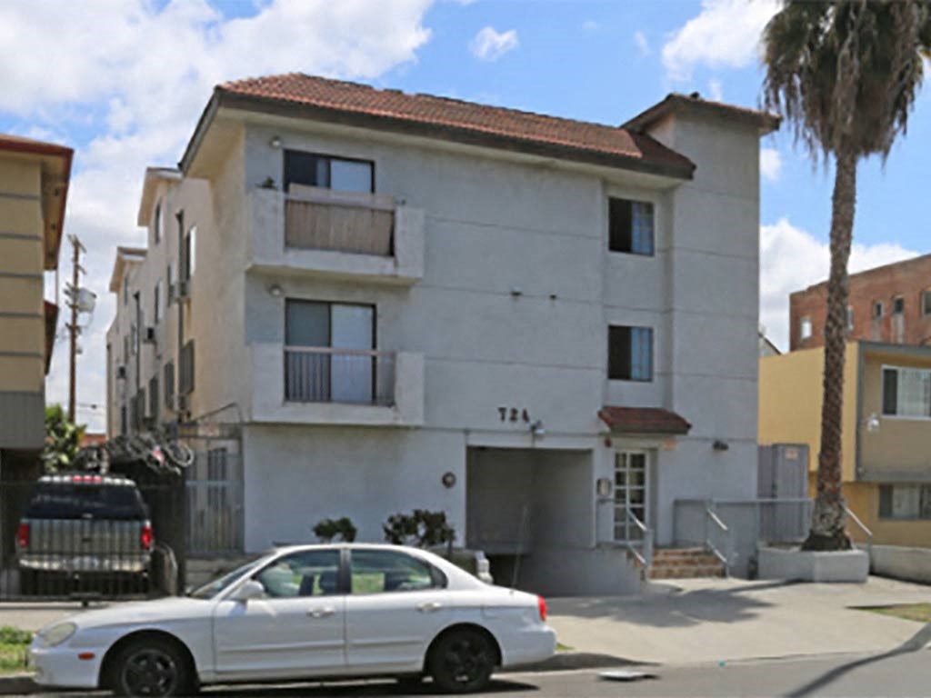 a white car parked in front of an apartment building
