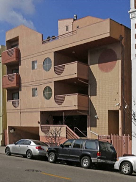 an apartment building with cars parked in front of it