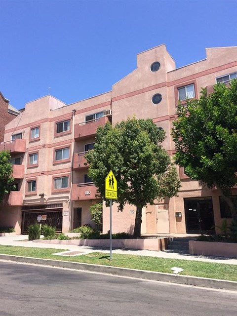 a yellow street sign in front of a building