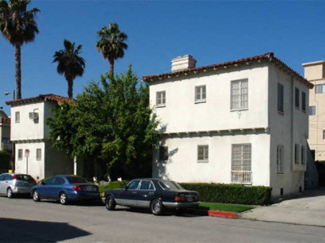 a white building with cars parked in front of it
