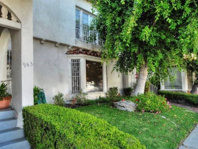 the front of a house with a yard and a tree
