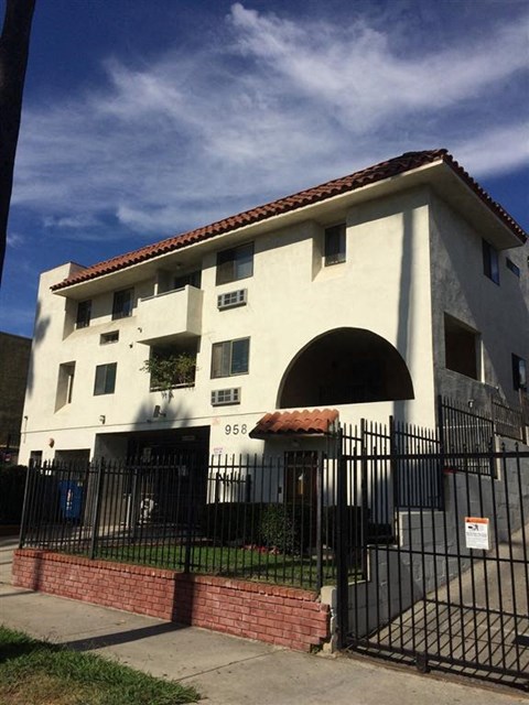 a white building with a wrought iron fence in front of it
