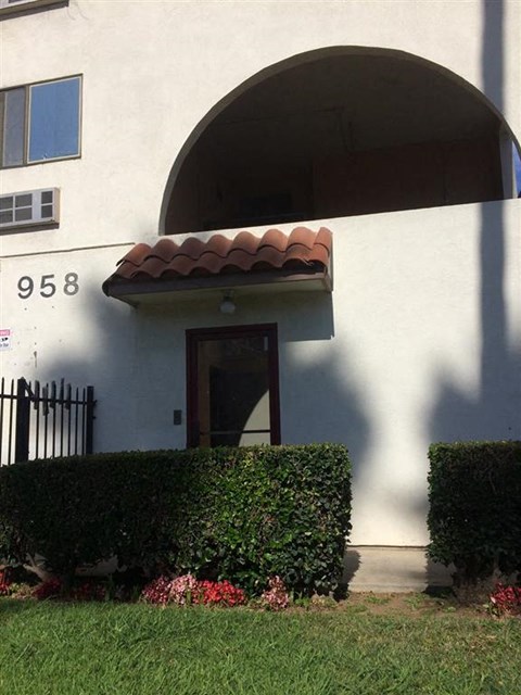 a building with a door and hedges in front of it