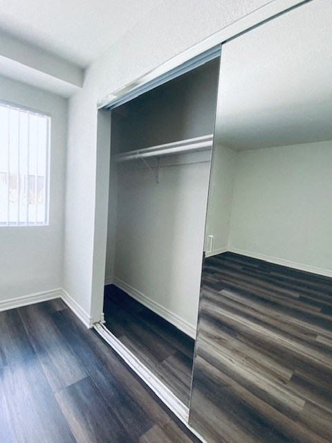 an empty bedroom with a sliding glass closet door