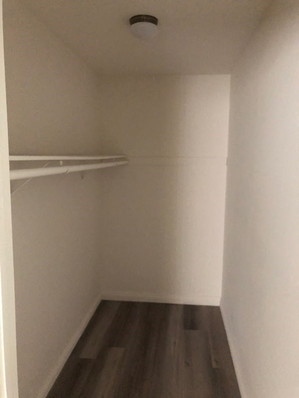 a small room with a closet and a clothes rack