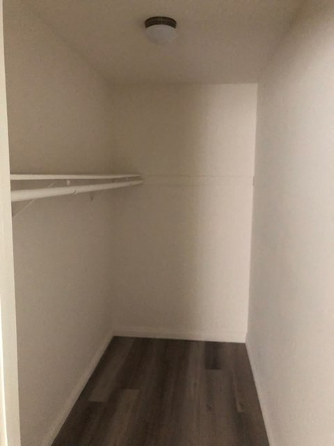 a small room with a closet and a clothes rack