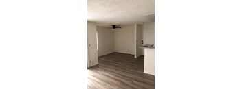 A room with a ceiling fan and light, and a counter with a marble top.