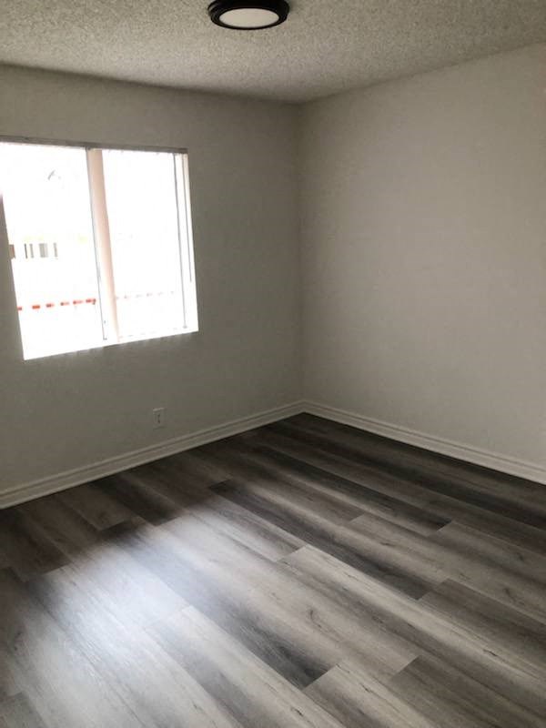 an empty room with wooden floors and a window