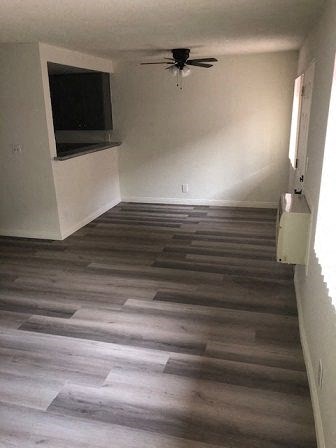 a living room with a wood floor and a ceiling fan