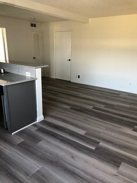 a kitchen and living room with wood flooring in a house