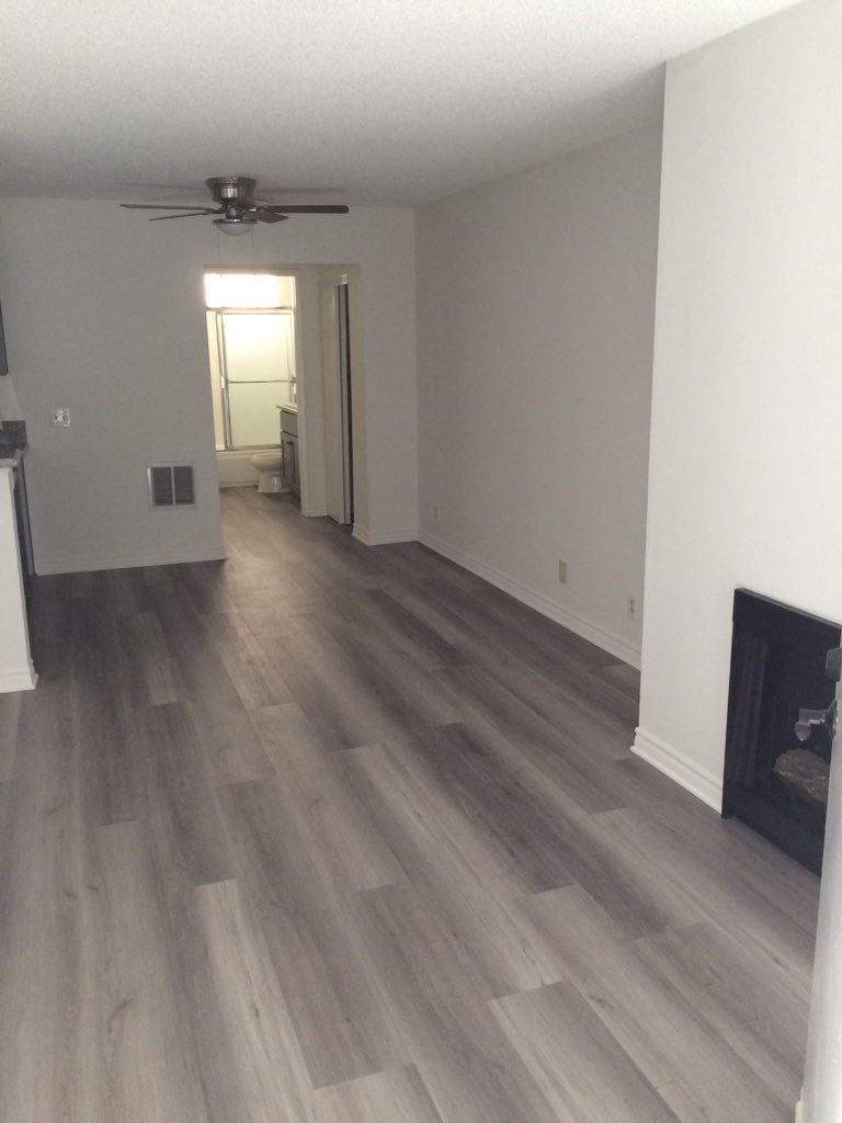 a living room with hardwood floors and a fireplace