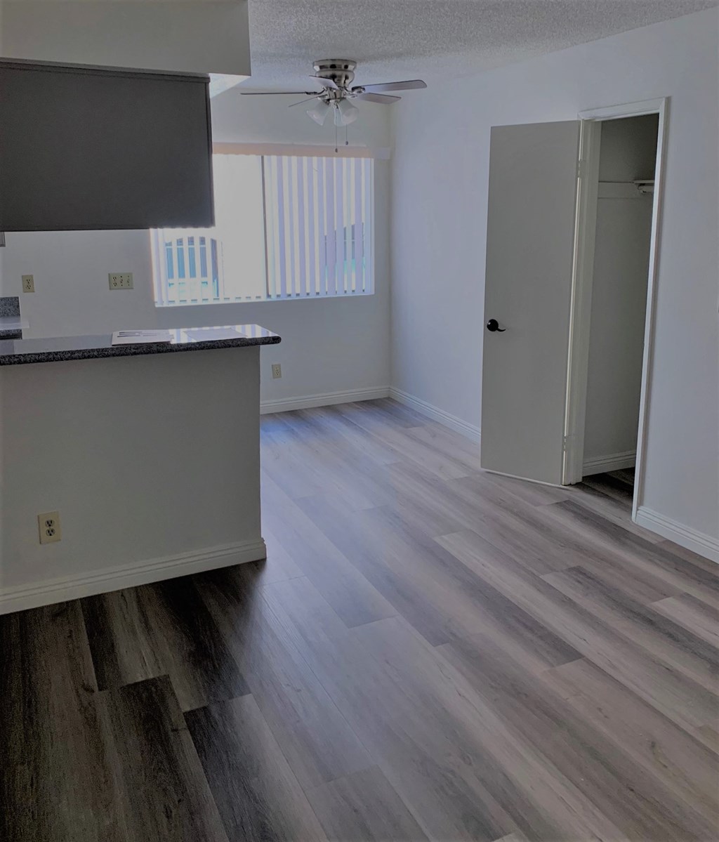 an empty kitchen and living room with wood flooring