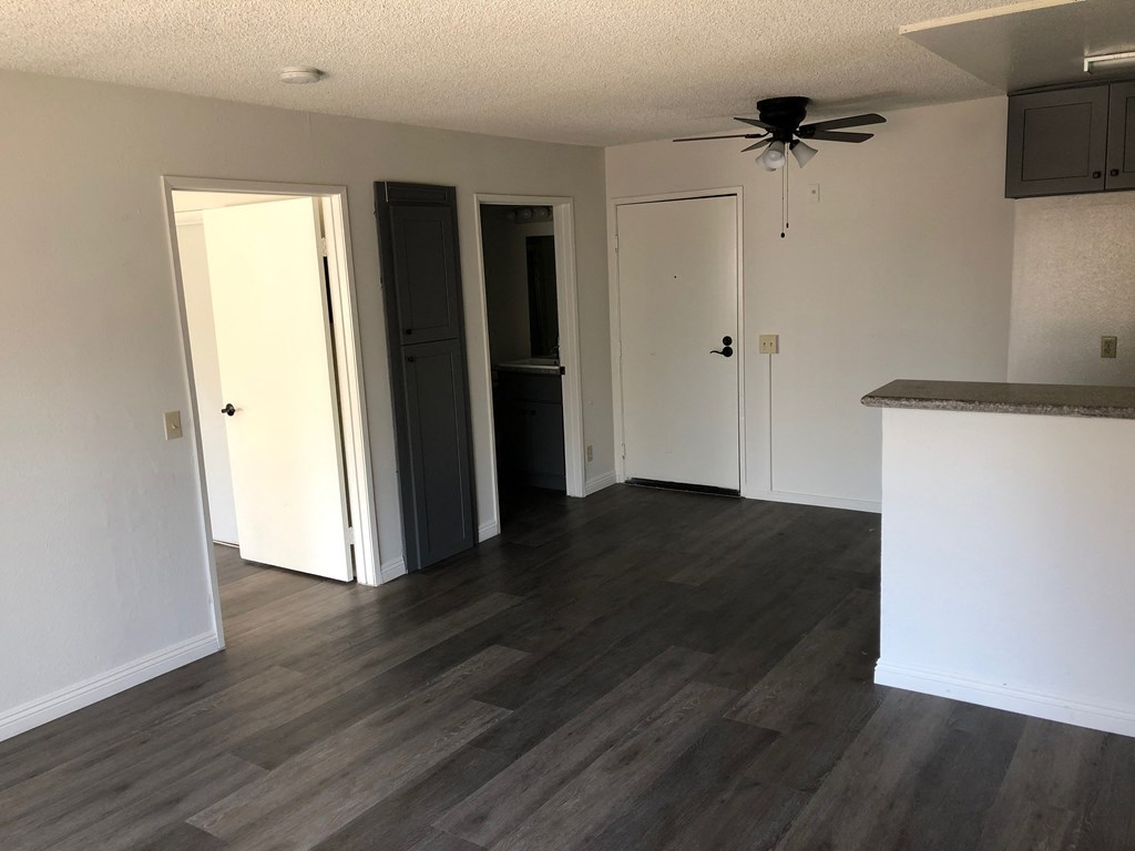 a renovated living room with wood floors and a ceiling fan