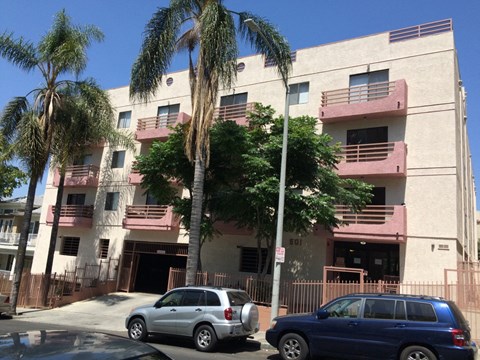 an apartment building with cars parked in front of it