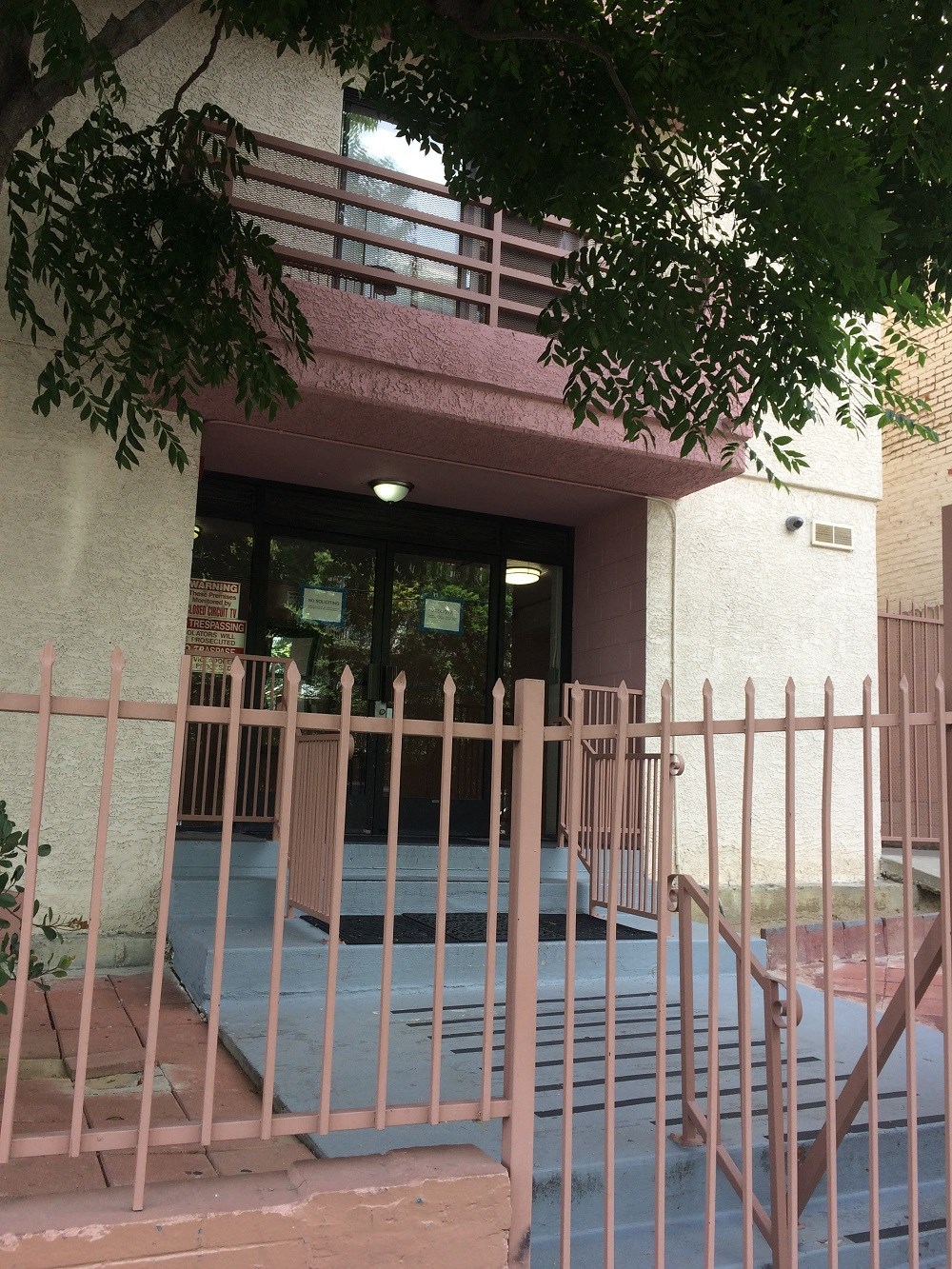 a porch in front of a building with a fence