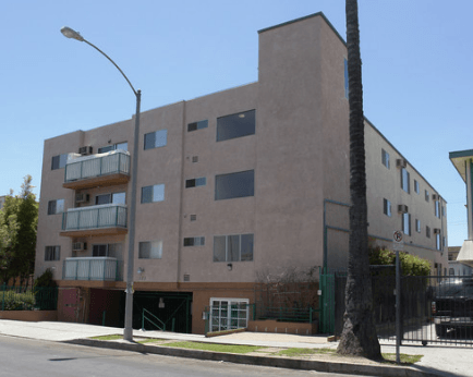 A tall building with a balcony on the second floor.