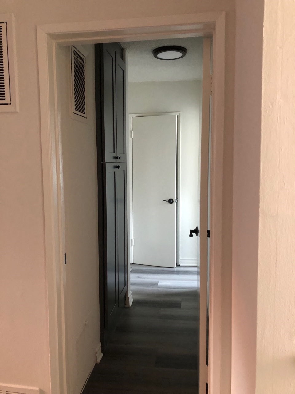 a hallway with a door open and a door to a closet